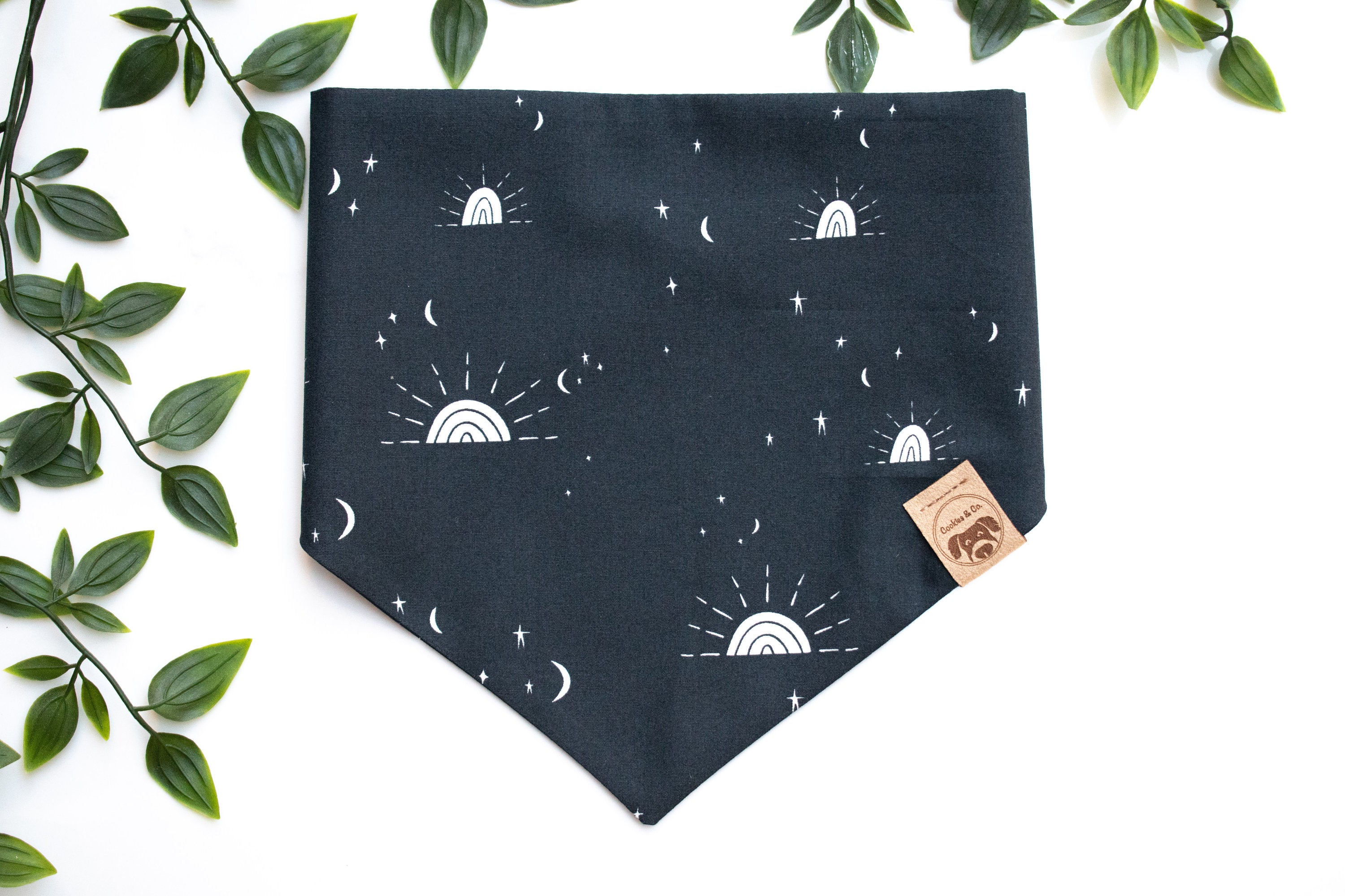 Desert Sunset bandana print, with white sunsets, stars, and moons in different sizes on a black background