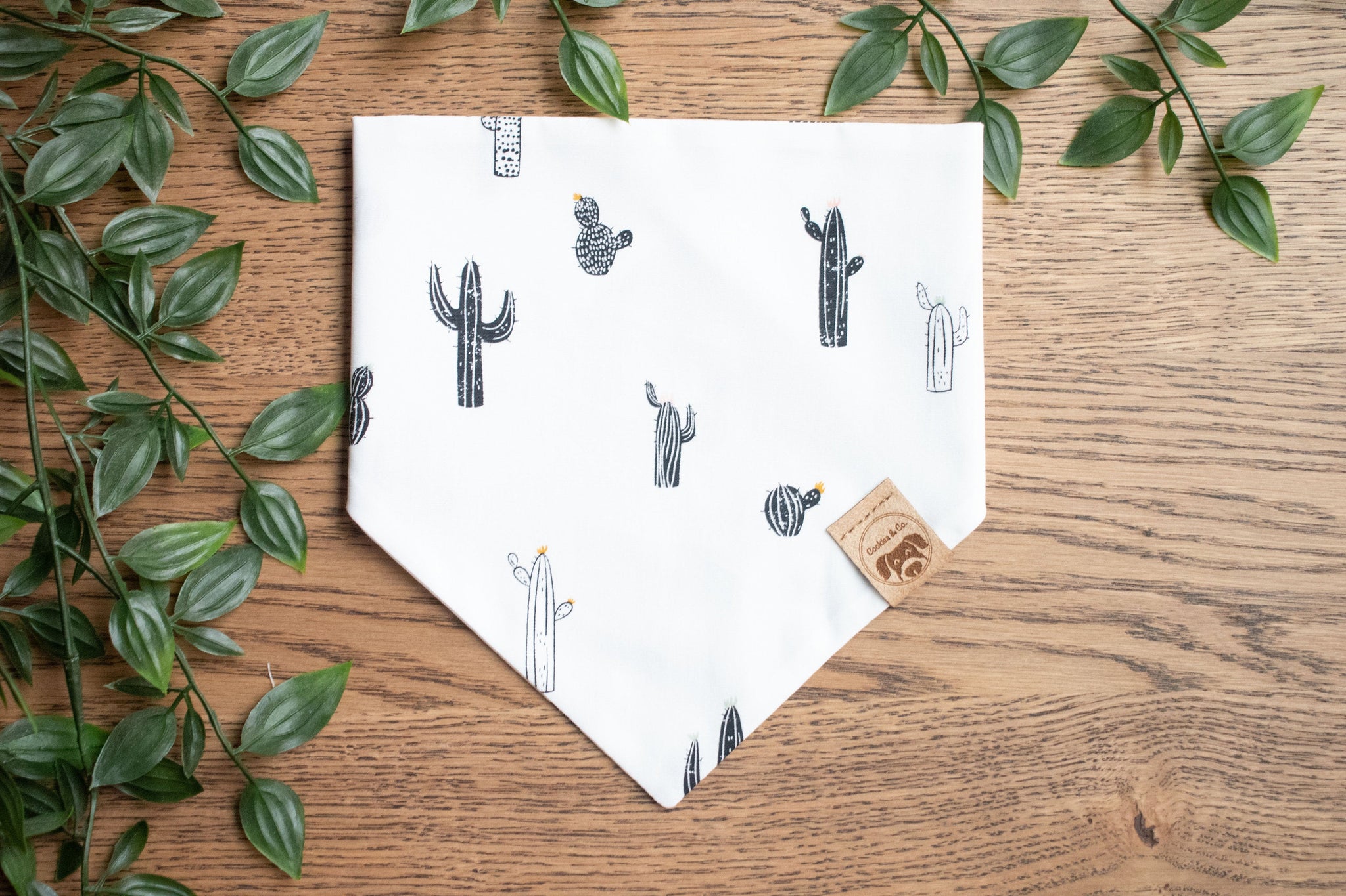 Joshua Tree bandana print, with a mix of black and white cacti in different sizes that have orange and light blue hair on a white background